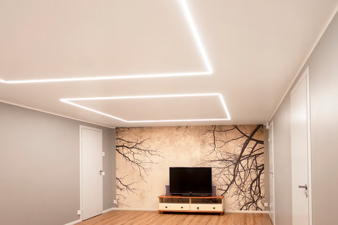 Minimalistinen olohuone perheen kodissa Espoon Kaitamäessä, jossa LedStore.fi:n LED-kattovalot luovat tyylikkään valaistuskokonaisuuden. Olohuoneessa on TV-taso sekä näyttävä seinämaalaus, jota korostaa laadukas LED-valaistus.