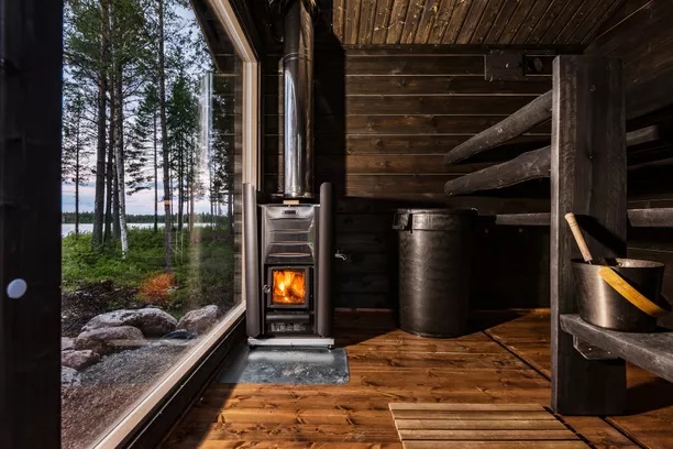 musta sauna tarvitsee paljon valoa, kuvassa seinän kokoinen ikkuna mustassa saunassa