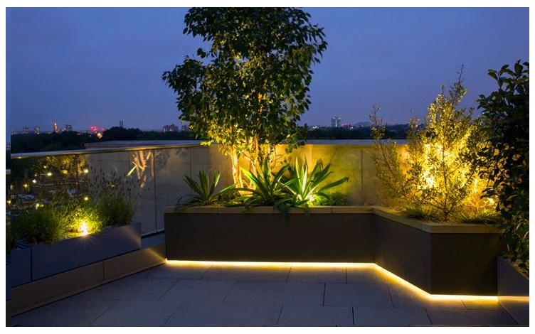roof-terrace-lighting - LedStore Korotettu kukkapenkki valaistu alareunasta lämpimänsävyisellä led nauhalla. Kukkapenkissä lisäksi muita lämpimänsävyisiä kohdevaloja.