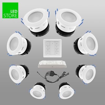 Set mit 8 weißen LED-Einbauleuchten, Bedienfeld, Netzgerät und Kabel auf grauem Hintergrund. Perfekt für energieeffiziente Beleuchtungslösungen.