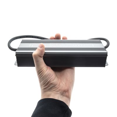 Handgehaltenes LED-Netzteil mit Kabeln an beiden Enden, ideal für energieeffiziente Beleuchtungslösungen, mit weißem Hintergrund.