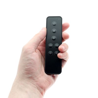 Elegante schwarze Fernbedienung mit 7 Tasten für LED-Beleuchtungssysteme, die für eine einfache Bedienung in der Hand gehalten wird. Perfekt für moderne Beleuchtungslösungen.