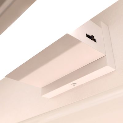 Nahaufnahme einer wandmontierten LED-Spielleuchte. Auf der Abdeckung der Lampe ist ein Schalter zu sehen.