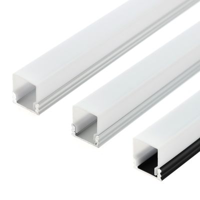 Nahaufnahme von drei weißen rechteckigen Aluminiumprofilen mit offenen Kanälen, die parallel auf einem weißen Hintergrund angeordnet sind. Ideal für LED-Beleuchtungslösungen.