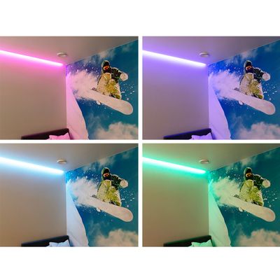Alternativer Text: Raumecke mit hellen LED-Lichtern in Pink, Lila, Blau und Grün, die ein Snowboardfahrer-Wandbild auf einem verschneiten Berghintergrund beleuchten.