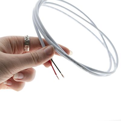 Nahaufnahme einer Hand, die einen weißen LED-Draht mit einem abgeschälten Ende hält, perfekt für individuelle Beleuchtungsinstallationen und energieeffiziente Lösungen.