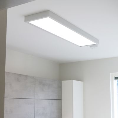 Moderne rechteckige LED-Deckenleuchte in einem minimalistischen Raum mit einer hellgrauen Wand und einem Fenster. Energieeffiziente Beleuchtung mit einer Shop-Funktion.