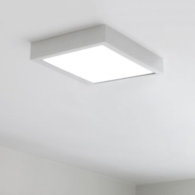 Eine quadratische LED-Deckenleuchte erhellt einen minimalistischen Raum mit strahlend weißen Wänden und Decken. Perfekt für die moderne Heimbeleuchtung.