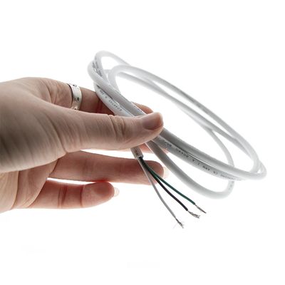 Nahaufnahme einer Hand, die ein weißes LED-Ringlicht mit sichtbaren Drähten vor einem dunklen Hintergrund für energieeffiziente Beleuchtung hält.