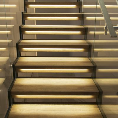 Moderne Holztreppe mit LED-beleuchteten Setzstufen und Handläufen aus Glas, die Ihrem Zuhause einen stilvollen und modernen Touch verleihen.