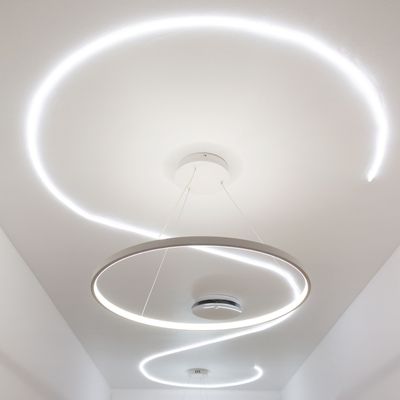 Das spiralförmige Muster der modernen runden LED-Deckenleuchten auf einem weißen Dach unterstreicht das moderne Lichtdesign.