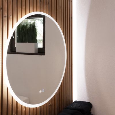 Runder LED-Spiegel beleuchtet eine hölzerne Salzwand; natürliches Licht, Topfpflanze, schwarzes Handtuch in der Nähe.