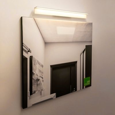LED-Wandleuchte beleuchtet einen quadratischen Spiegel, einen reflektierenden Korridor an einer Tür und ein abstraktes Kunstwerk. Modernes Lichtdesign für stilvolle Innenräume.