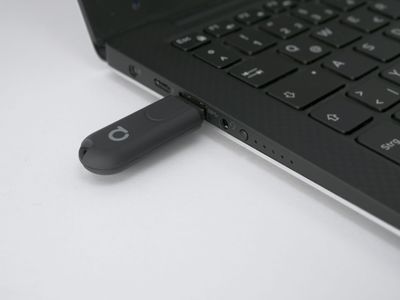 USB-Flash-Laufwerk, angeschlossen an einen Laptop auf weißem Hintergrund, symbolisiert Konnektivität und Technologie in modernen LED-Beleuchtungslösungen.