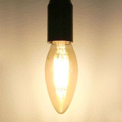 Eine energieeffiziente LED-Lampe mit schwarzem Sockel, die ein modernes Interieur vor einer schlichten Wand akzentuiert.