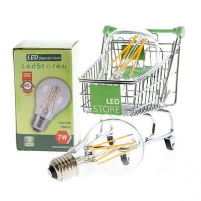 LED-Glühbirne in einem Mini-Einkaufswagen neben einer grünen LED-Ladenbox, die energieeffiziente Beleuchtungsmöglichkeiten aufzeigt.