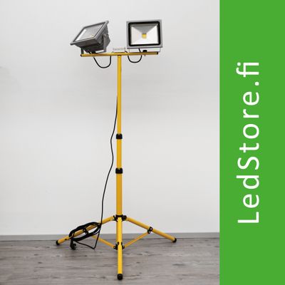 Doppelköpfige gelbe LED-Arbeitsleuchte mit Ständer, weißer Hintergrund. Grüner Text "LedStore.fi" daneben. Ideal für professionelle und häusliche Beleuchtung.