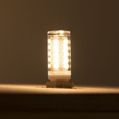 Alternativer Text: "Warm leuchtende kleine LED-Lampe vor einem dunklen Hintergrund in einem LED-Beleuchtungsgeschäft.