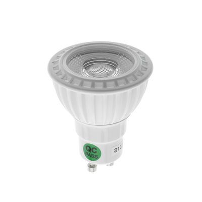 LED-Glühbirne mit GU10-Sockel und "QC PASS"-Stick, vertikal montiert vor weißem Hintergrund für LED-Beleuchtungsbewegung.