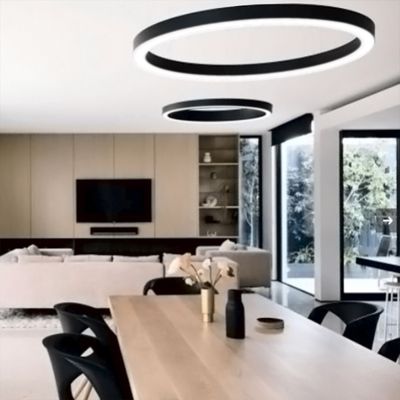 Moderne LED-Deckenleuchten beleuchten einen geräumigen Wohn-/Essbereich mit Holztisch, beigem Sofa, TV an der Wand, großen Fenstern und minimalistischem Dekor.