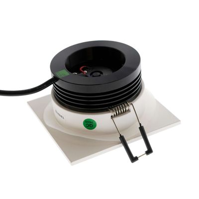 Schwarz-weißes quadratisches LED-Downlight mit Federklemme und schwarzem Kabel auf weißer Oberfläche - die perfekte moderne Beleuchtungslösung.