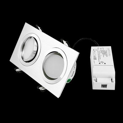 Zwei runde LED-Leuchten in einem eleganten silbernen Rahmen und weißem Stromkonverter, elegantes Design mit schwarzem Hintergrund für moderne Beleuchtungslösungen.