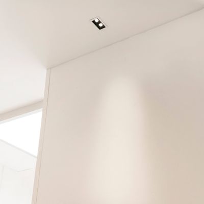 Ein minimalistischer Raum mit weißer Decke und Wänden und einer stilvollen rechteckigen LED-Einbauleuchte für moderne Beleuchtung.