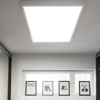 LED-Deckenleuchte, die einen Raum mit gerahmter Kunst, einschließlich Hut- und Panda-Motiven, in der Nähe eines Fensters beleuchtet. Perfekt für Innenräume mit Modethemen.