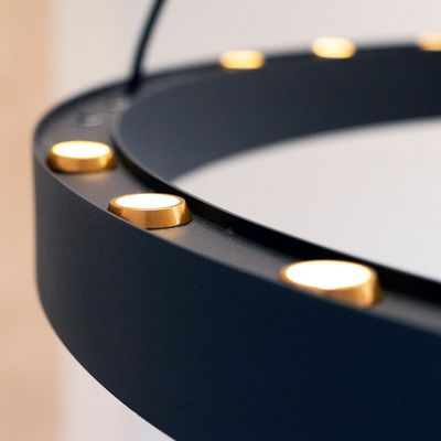Nahaufnahme eines schwarzen, runden LED-Ringlichts mit gleichmäßig verteilten goldenen Lichtern, perfekt für Fotografie und Videobeleuchtung.
