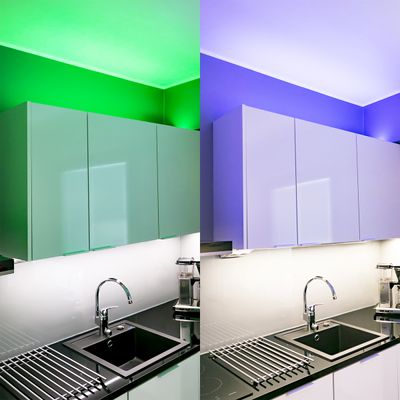 Moderne Küche mit stilvollen Schränken und Spüle, beleuchtet durch grüne LED-Beleuchtung auf der einen Seite und blaue LED-Beleuchtung auf der anderen Seite.