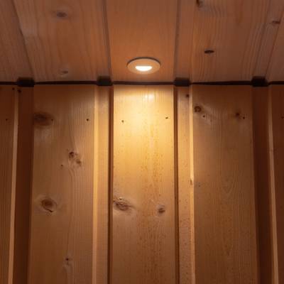 Eine warme, natürliche Holzdecke mit eingebauter LED-Beleuchtung und vertikalen Paneelen sorgt für eine gemütliche Atmosphäre.