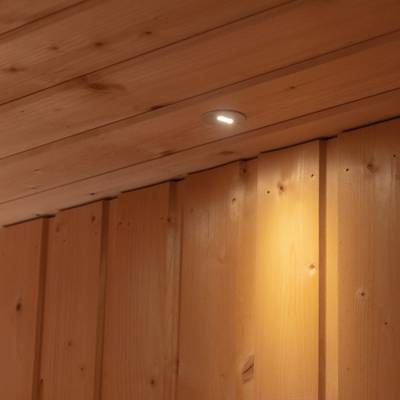 Eine an der Decke montierte LED-Leuchte beleuchtet die hölzernen Wandpaneele darunter.