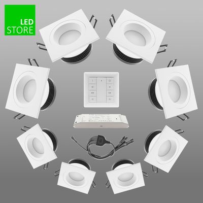 Acht weiße quadratische LED-Downlights in kreisförmiger Anordnung mit zentralem Bedienfeld und Kabeln, eine ideale energieeffiziente Beleuchtungslösung.