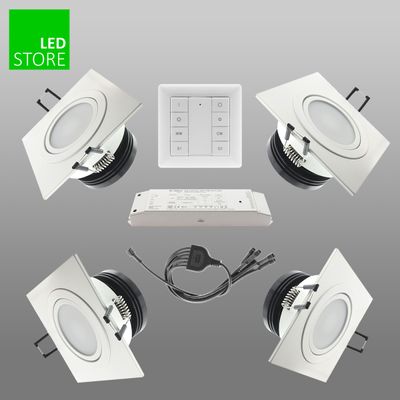 Vier quadratische LED-Downlightsets, Fernbedienung, Netzteil auf grauem Hintergrund, grünes "LED STORE"-Schild für hochwertige Beleuchtungslösungen.