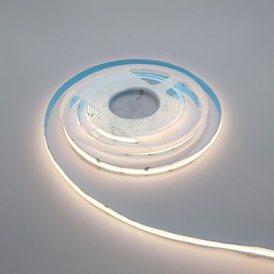 Gedrehtes LED-Lichtband, teilweise abgerollt, leuchtet sanft auf einer schlichten weißen Oberfläche. Perfekt für energieeffiziente Beleuchtungslösungen zu Hause und in Unternehmen.