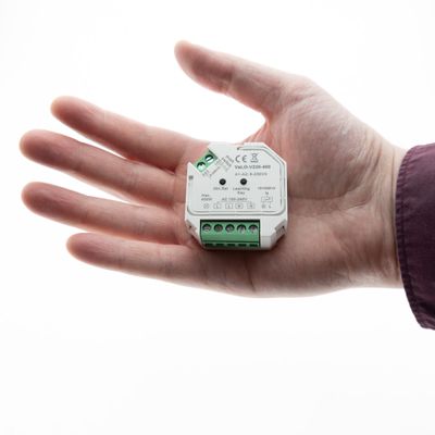 Nahaufnahme einer Person, die eine LED-Beleuchtungskomponente mit Steckern hält, die ideal für energieeffiziente Beleuchtungslösungen ist, vor einem weißen Hintergrund.