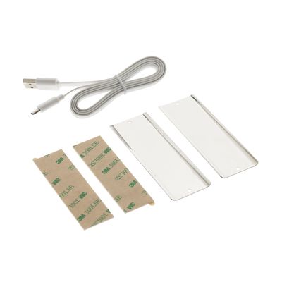 Installationskit für LED-Beleuchtung: USB-Kabel, Klebestreifen und rechteckige weiße Kunststoffteile mit weißem Hintergrund.