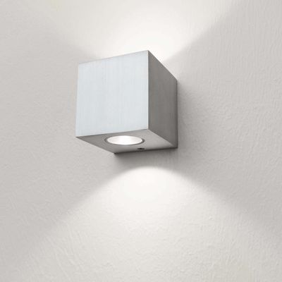 Alternativtext: "Moderne quadratische LED-Wandleuchte mit strukturierter weißer Wand, leuchtet sanft nach oben und unten.