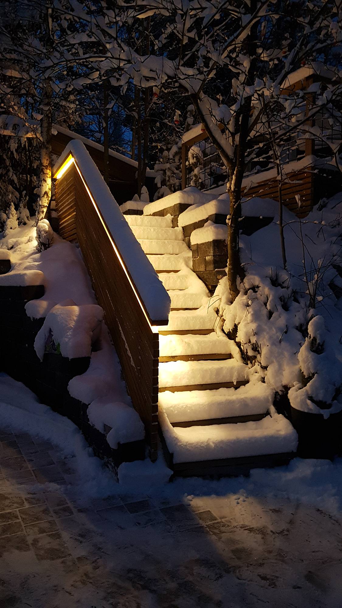 Beleuchtung einer Außentreppe mit LED-Streifen an der Balustrade. Das Licht ist atmosphärisches indirektes Licht, das verwendete LED-Band ist ein warmes 3000K 7,2W/m Band. Ledstore.fi