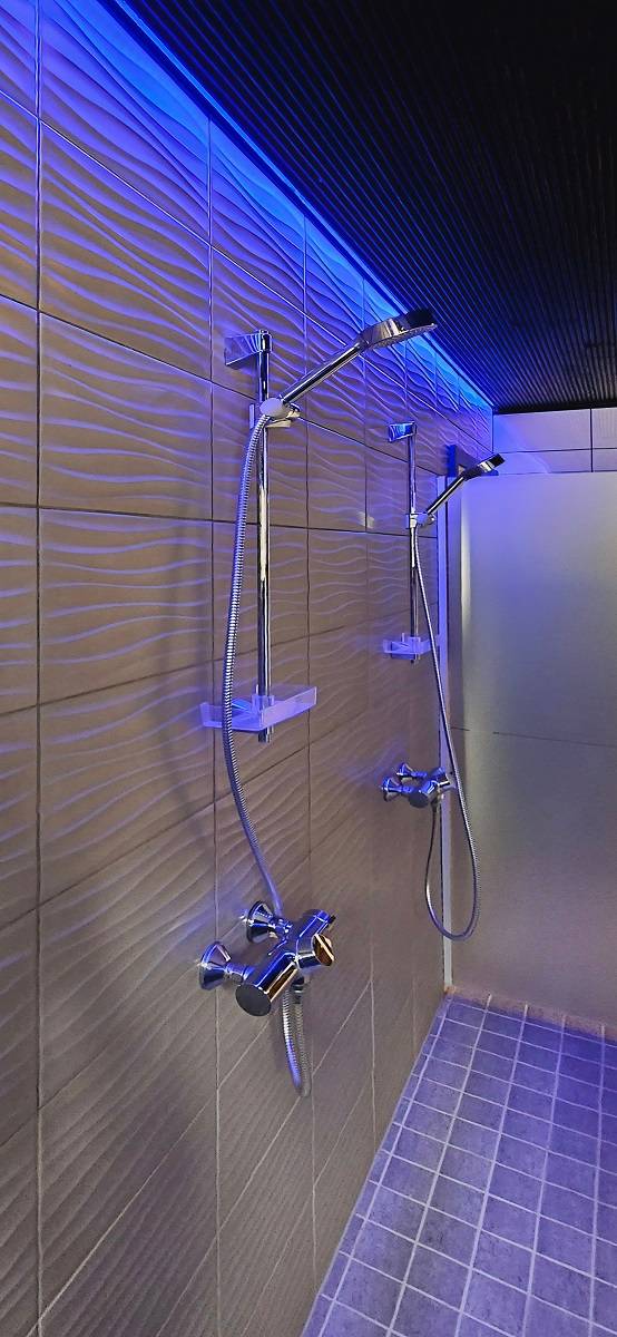 Die Waschräume auf der Männerseite sind mit RGB-Lichtbändern über den Duschen von der Decke aus beleuchtet, Foto von The Punchers