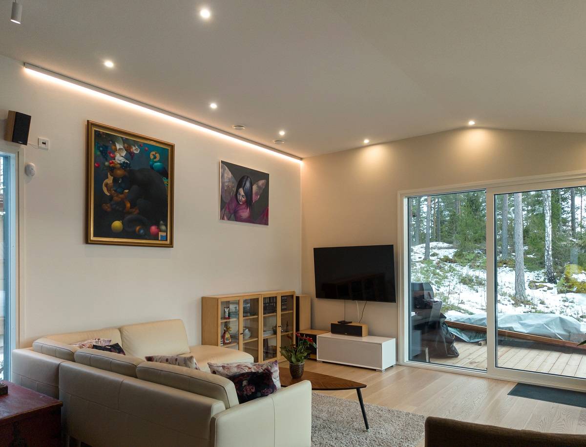 Wohnzimmer mit mehreren Strahlern und einer Wand mit LED-Leuchtband.