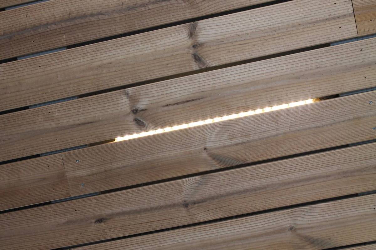 Wohnungsbau-Messe 2014: Stücke eines Led-Streifens über einem Schlitz in der Platte, Nahaufnahme. Ledstore.fi