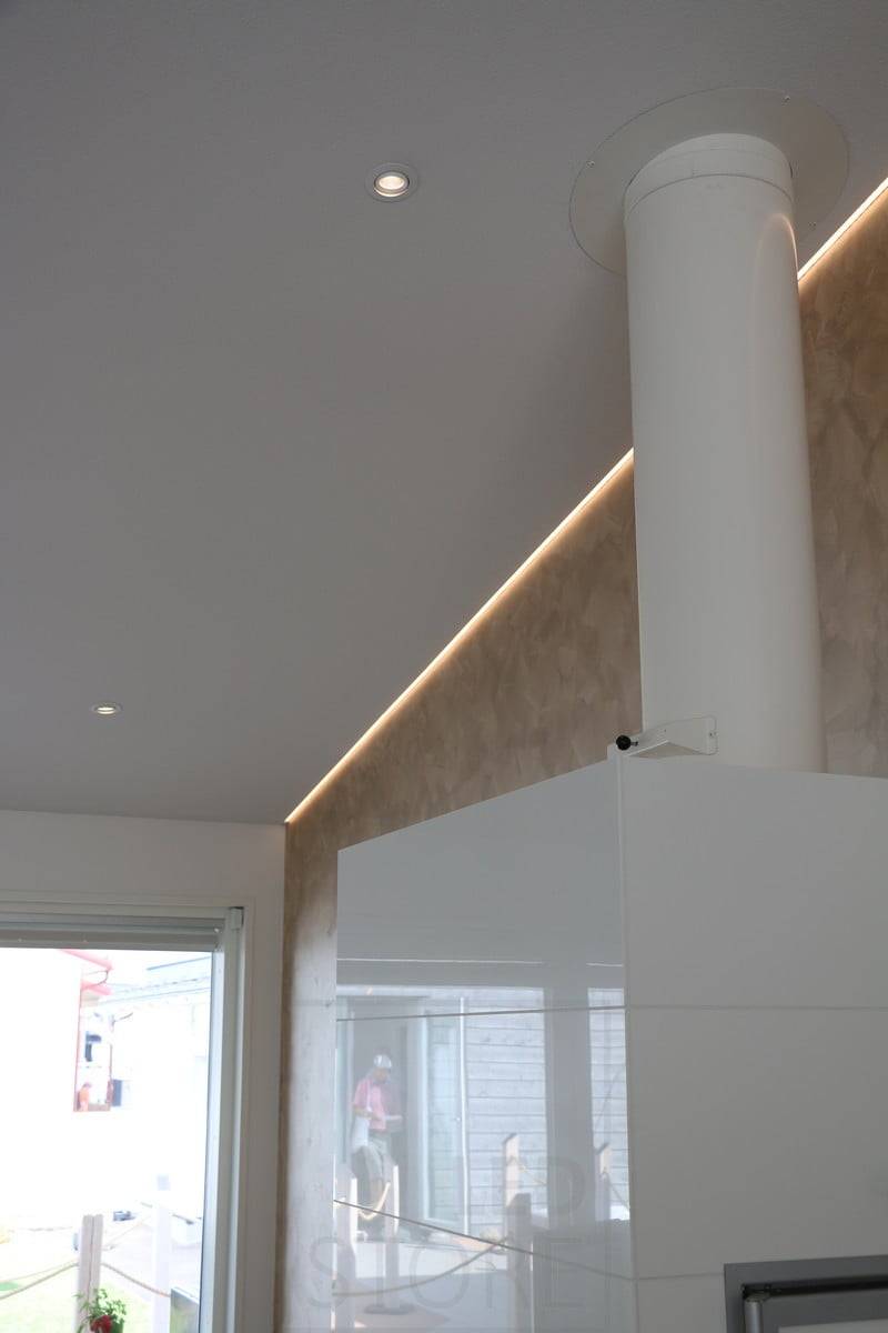 Wohnmesse 2018: Led-Profil an einer schrägen, ansteigenden Decke, an der Schnittstelle Wand/Decke, hinter dem Kamin. Ledstore.fi