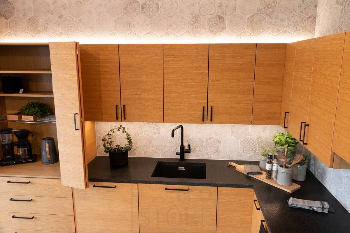 Wohnmesse 2020: indirekte Beleuchtung über dem Küchenschrank und Beleuchtung der Arbeitsplatte in der Eichenholzküche. Ledstore.fi