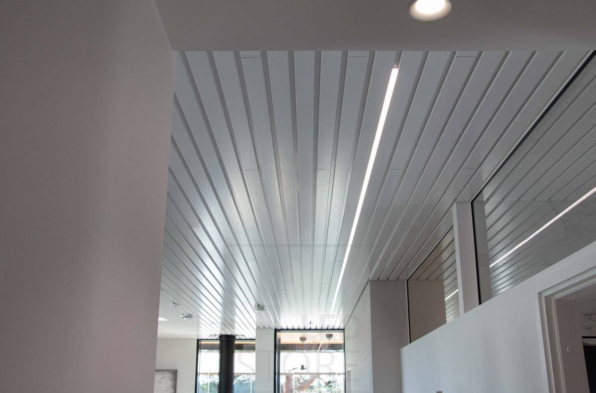 Wohnmesse 2022: Weißes LED-Profil, das in die Fuge einer Deckenplatte im Wohnzimmer eingelassen ist. Ledstore.fi