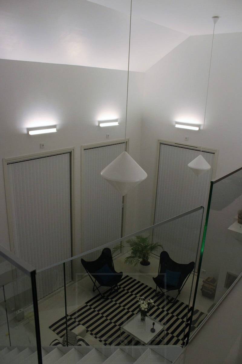 Ein Wohnzimmer mit stimmungsvoller indirekter Beleuchtung, die mit Led BLADE Wandleuchten erzeugt wurde. Die Leuchte ist so montiert, dass sie von unten nach oben leuchtet, so dass die indirekte Beleuchtung auch die Höhe des Raumes betont. Ledstore.fi