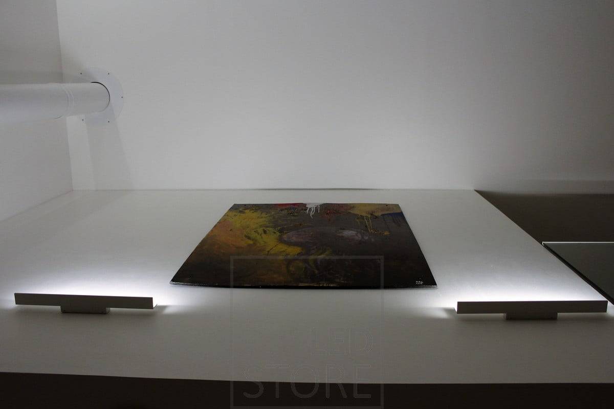 Blade-Wandleuchte, die von unten nach oben leuchtet und das Kunstwerk mit indirektem Licht hervorhebt. Ledstore.fi