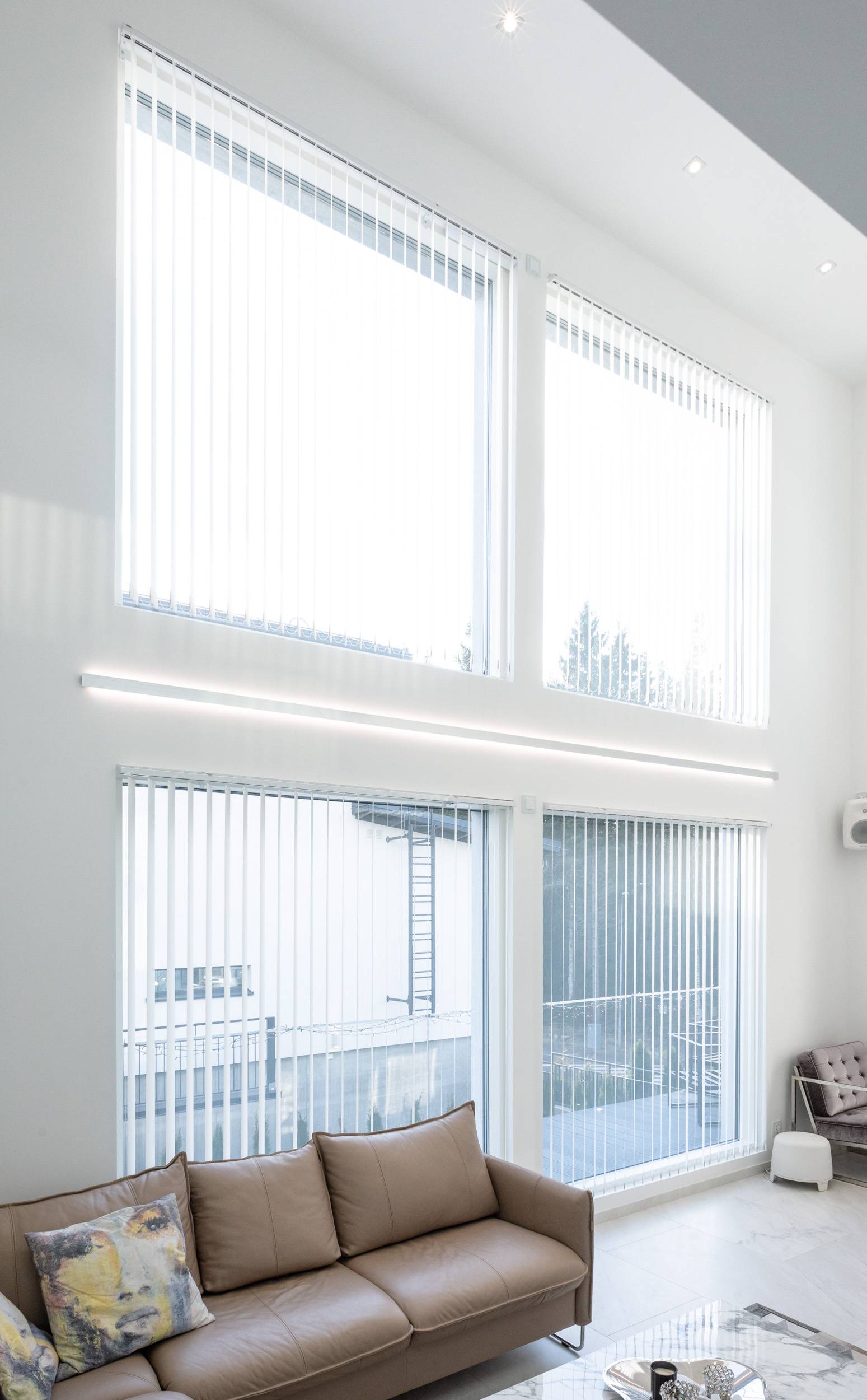 Indirekt beleuchtetes 2-Wege-Aluminiumprofil, das an der Wand montiert wird. Zusätzlich Downlights an der Decke.