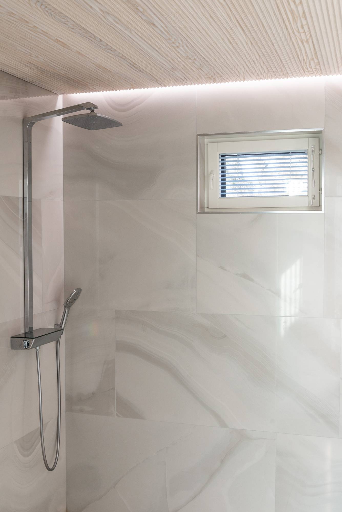 Led-Leiste zwischen Decke und Wand, die die Dusche indirekt beleuchtet und eine Wellness-Atmosphäre schafft. Ledstore.fi