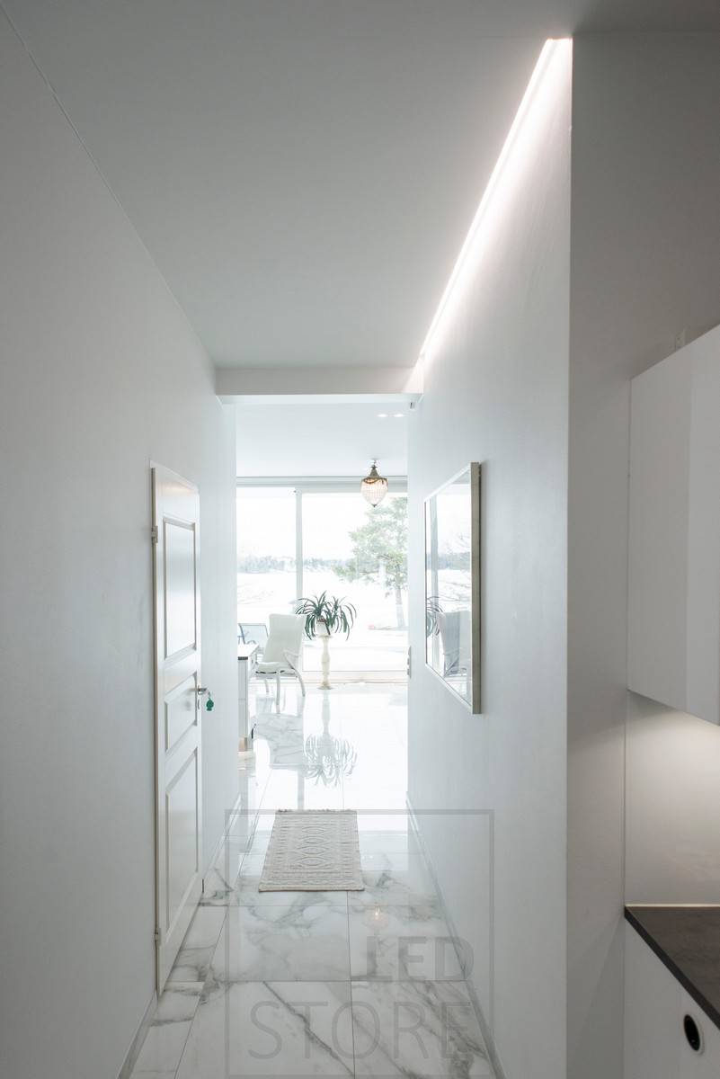 Mit indirektem Licht beleuchteter Korridor, LED-Streifen in einer Nut zwischen Decke und Wand in einem Aluminiumprofil montiert. Ledstore.fi